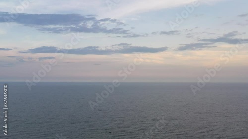 Wallpaper Mural Aerial view to sunset delicate, neutral, beige, nude sky and clouds on sea. Dark water with boat, light, dim, pastel shades of the sky Torontodigital.ca