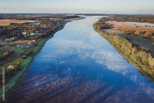 Beautiful aerial view of the river. Early morning landscape. Foggy river. River valley in the morning fog at sunrise. View from above.