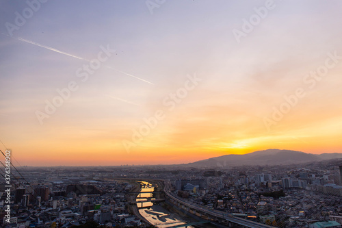 山に沈む夕日と住宅地と河川