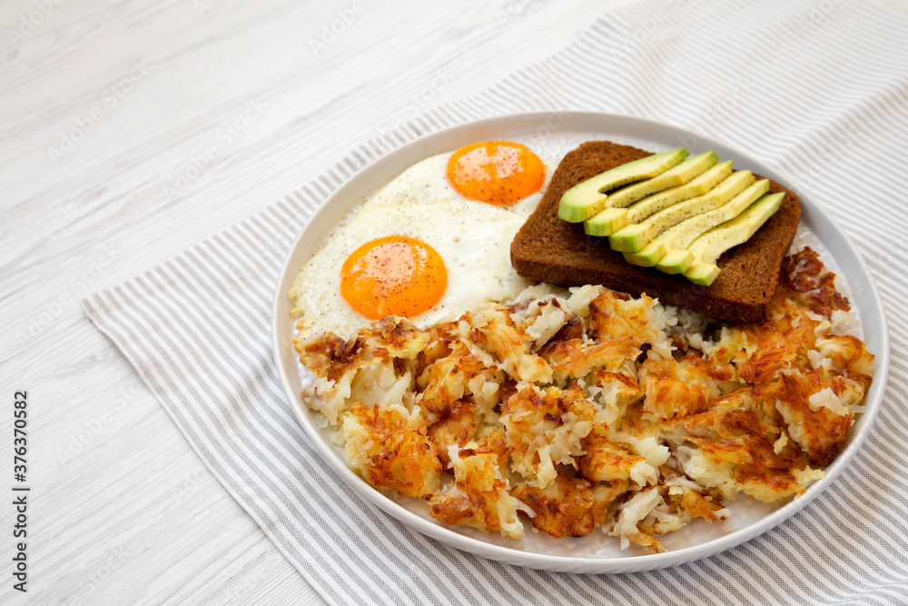 Tasty Homemade Fried Hashbrowns and Eggs on a plate, side view. Copy space. Tasty Homemade Fried Hashbrowns and Eggs on a plate, side view. Copy space.