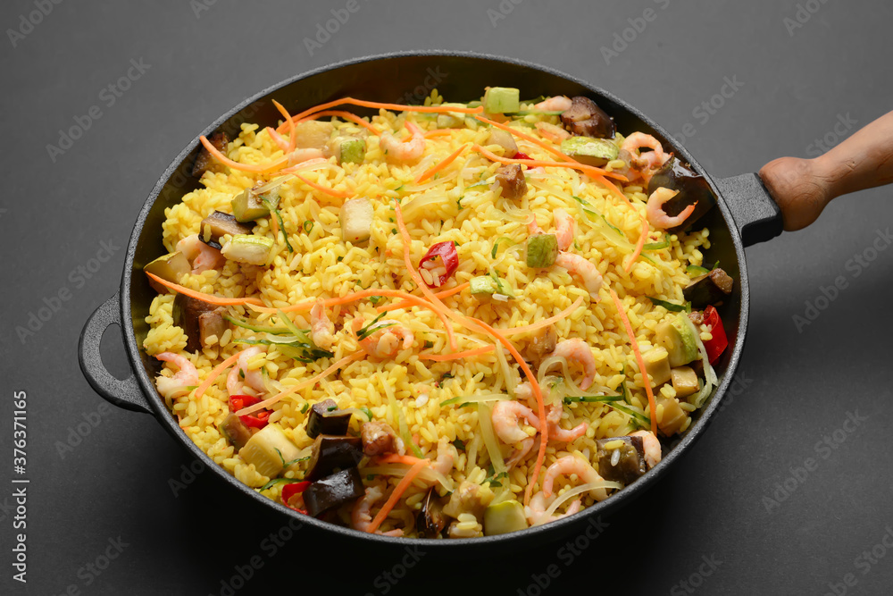 Frying pan with tasty rice on dark background Frying pan with tasty rice on dark background