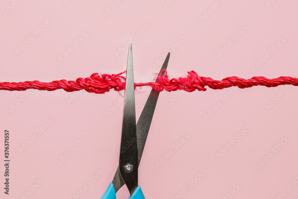 Scissors with frayed rope on color background - obrazy, fototapety, plakaty 