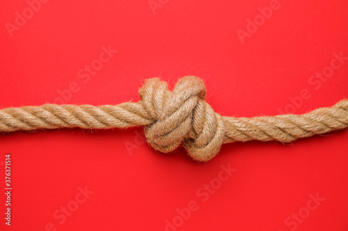 Rope with knot on color background