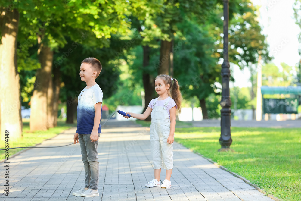 Obraz premium Cute little children jumping rope outdoors