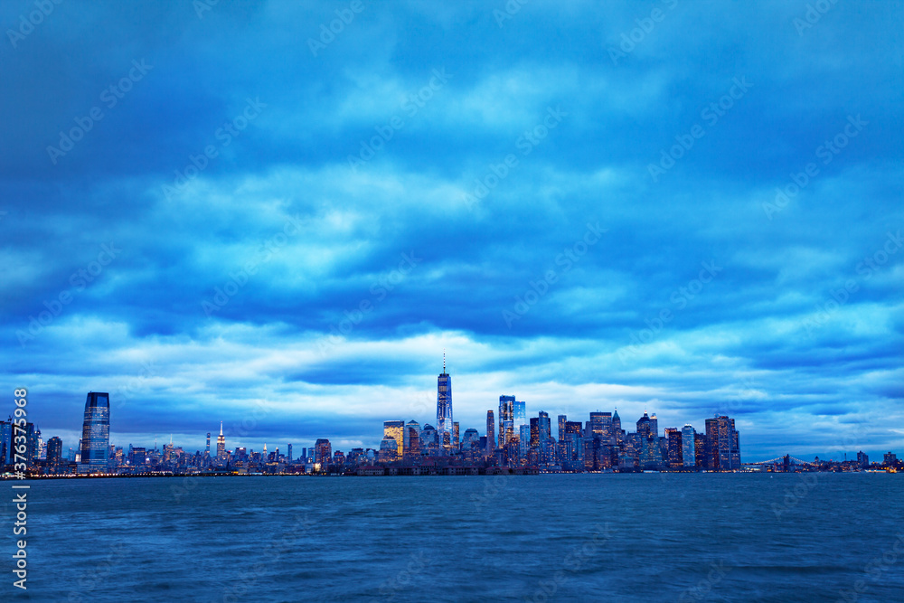 Dramatic panorama of New York Manhattan downtown over Hudson from Jersey City overcast day