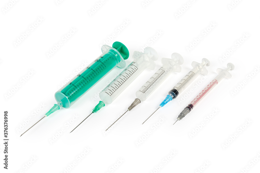 Different disposable medical syringes with needles on a white background Different disposable medical syringes with needles on a white background