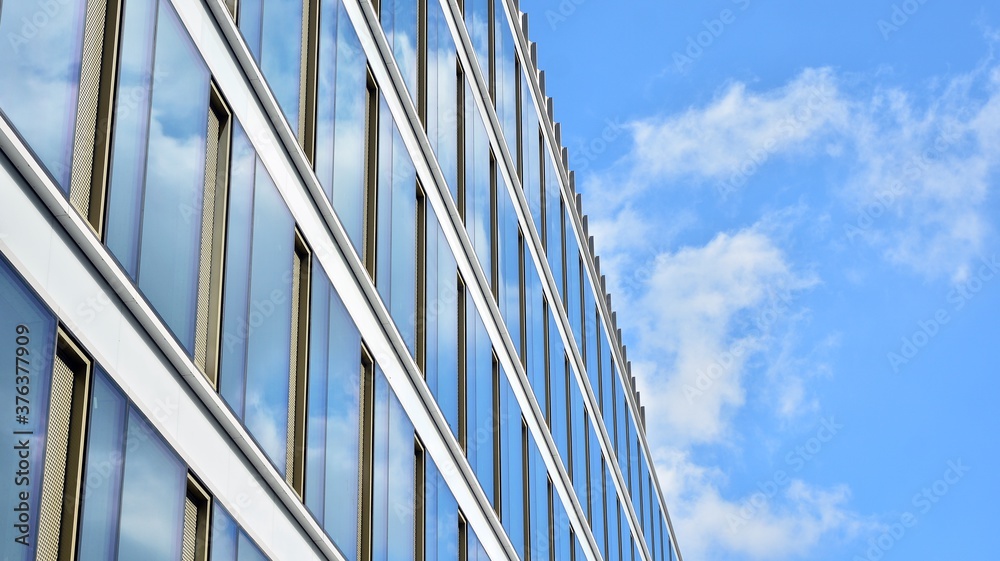 Office building, blue glass wall reflection detail. Modern office building and clear sky background. Office building, blue glass wall reflection detail. Modern office building and clear sky background.