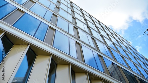 Office building  blue glass wall reflection detail. Modern office building and clear sky background. 