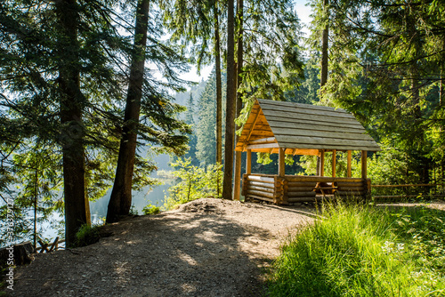 wooden gazebo in the woods near the lake. camping picnic shelter in the woods.