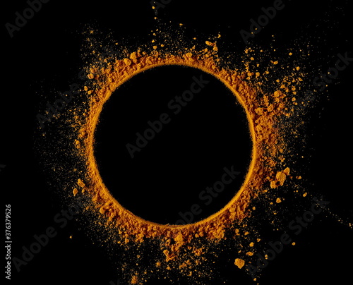 Turmeric (Curcuma) powder pile, round frame and border isolated on black background, top view
