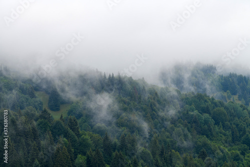 Majestic view on beautiful fog and cloud mountains in mist landscape. © byrdyak