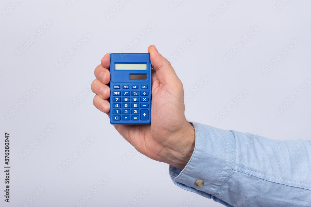 Male hand holding calculator on white background. Financial activity. Accounting Male hand holding calculator on white background. Financial activity. Accounting
