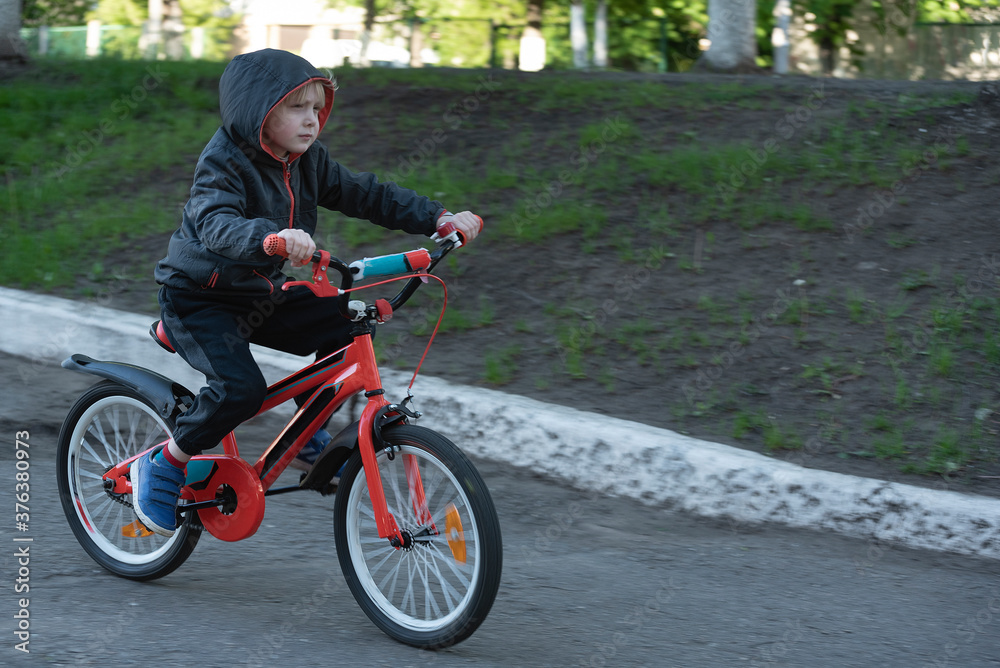 Spring bike ride. boy learning to ride a bicycle. Child rides Bicycle on paved road