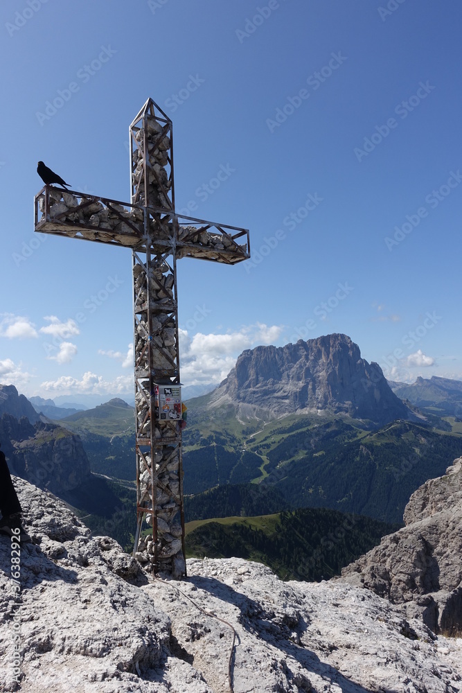 Crow sitting on summit-cross at langkofel italy Crow sitting on summit-cross at langkofel italy