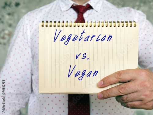 Healthy concept about Vegan Vs Vegetarian with inscription on the sheet. photo