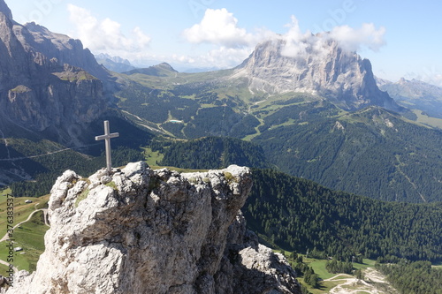 Wooden cross on front of langkofel, dolomites