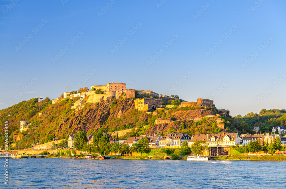 Ehrenbreitstein Fortress medieval building on hill of east steep bank of Rhine river, view from Koblenz city, blue sky background, North Rhine-Westphalia region, Germany