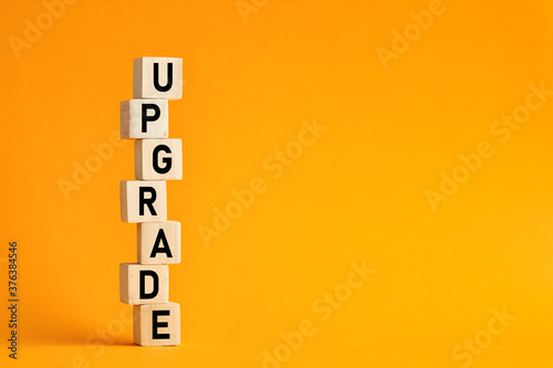 The word upgrade on wooden cubes. Computer, network, internet business technology upgrade concept.