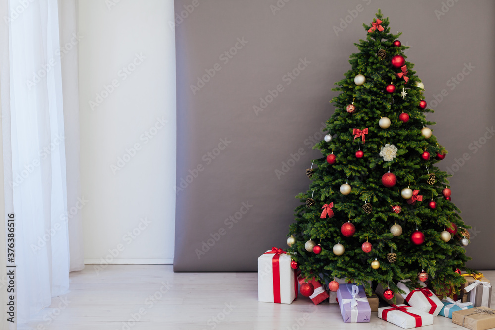 The interior of the room is a green Christmas tree with red gifts for the new year decor of the winter holiday home The interior of the room is a green Christmas tree with red gifts for the new year decor of the winter holiday home