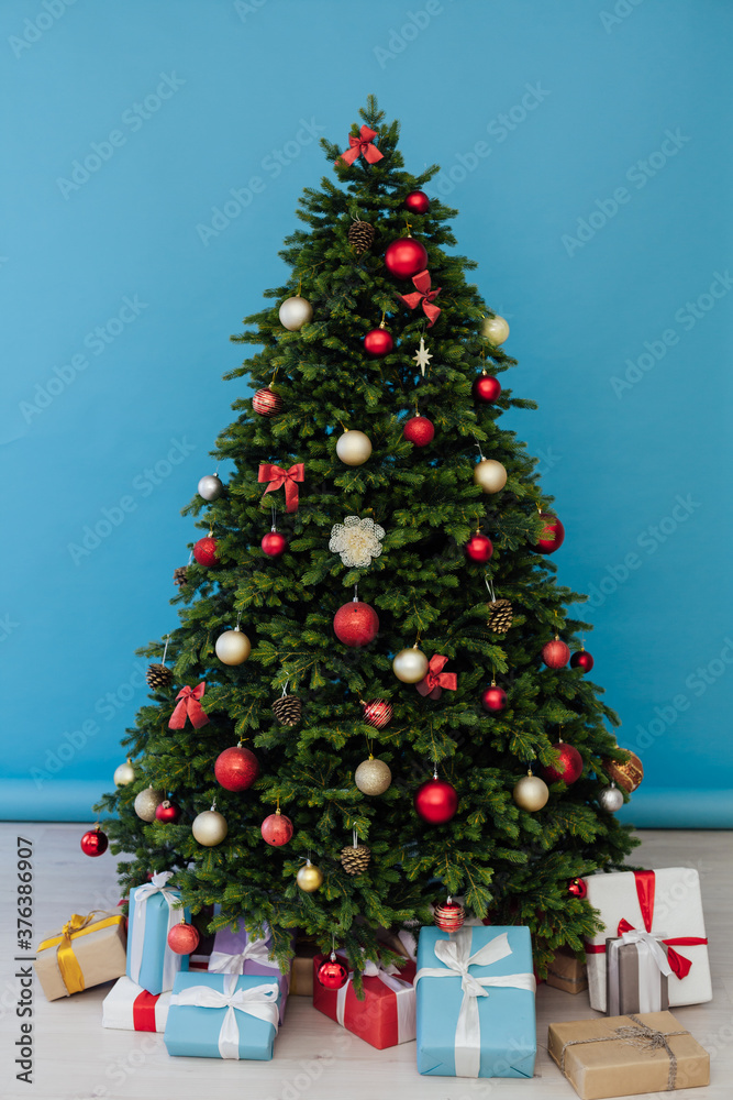 The interior of the room is a green Christmas tree with red gifts for the new year decor of the winter holiday home The interior of the room is a green Christmas tree with red gifts for the new year decor of the winter holiday home