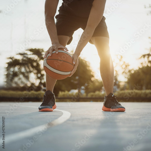 Man playing basketball. Man dribbling a basketball outdoor. © sarayutsridee