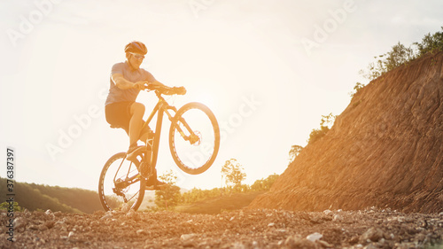Man is riding mountainbiker performs a wheelie and balancing on one wheel with his acrobatic bike.healthy lifestyle.xtreme sports.vintage tone.selective focus.