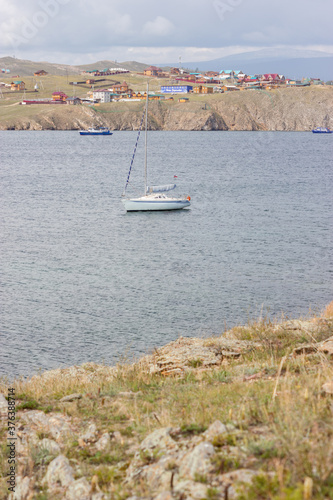 Yacht in the bay against the background of the village photo