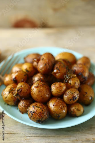 Selective focus. Macro. Fried potatoes in their skins on a plate. Rustic potatoes.