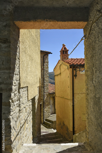 A small road crosses the old buildings of Catelmezzano, a rural village in the Basilicata region, Italy. 