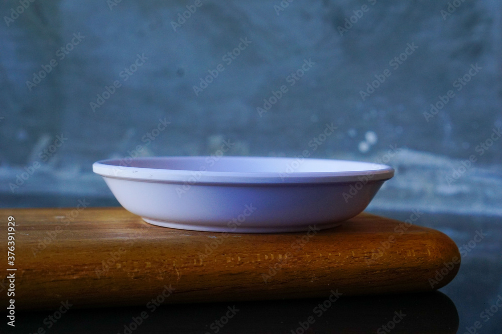 empty white plate on wooden board. kitchen life concept for cafe restaurant menu