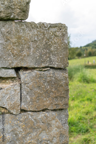 Corner of a stone wall made of rough masonry