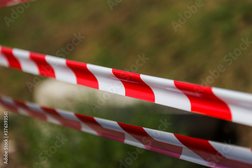 Red and white striped warning about danger and limited access tape tape. Red and white striped stretched warning barricade tape