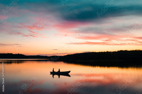Scenic view of men fishing in Saimaa Lake during sunset