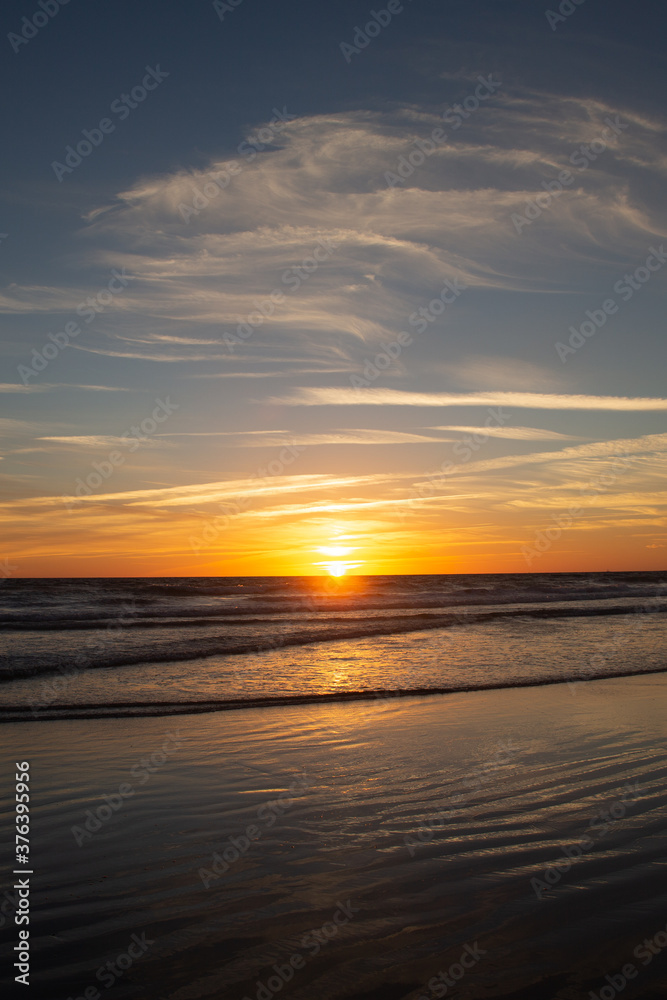 Sunset in the long beach of Zahara de los Atunes marking the horizon line in the Atlantic Ocean, Cadiz, Spain