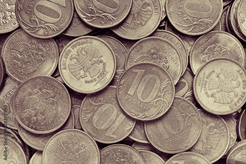 Surface of many Russian coins of 10 ten rubles. Burgundy yellow toned background or wallpaper. Backdrop on the theme of the economy, finance and the central bank of Russia. View from above. Macro Surface of many Russian coins of 10 ten rubles. Burgundy yellow toned background or wallpaper. Backdrop on the theme of the economy, finance and the central bank of Russia. View from above. Macro
