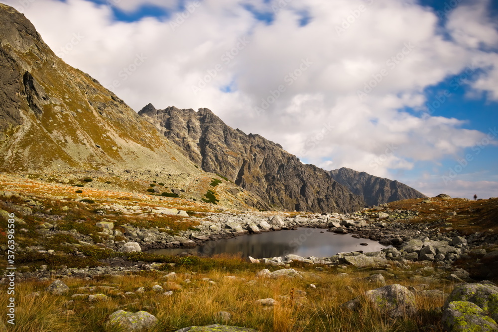 A small mountain lake surrounded by rocks in autumn