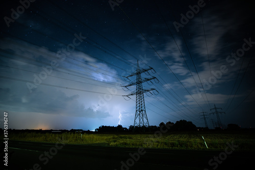 Powerlines in front of a Thunderstorm over a field