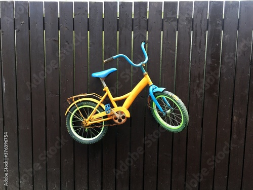  Старый детский велосипед окрашенный как украшение забора