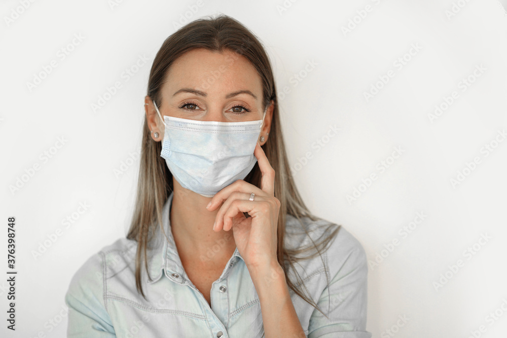 Woman standing on white background wearing face mask Woman standing on white background wearing face mask