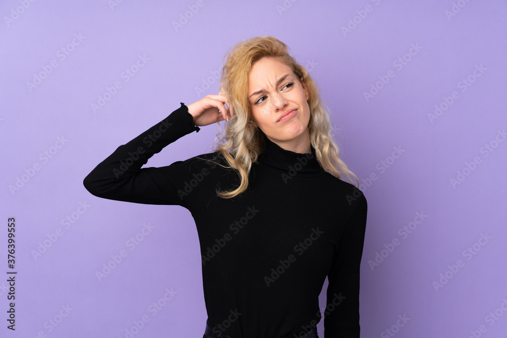 Fototapeta premium Young blonde woman isolated on purple background having doubts and with confuse face expression