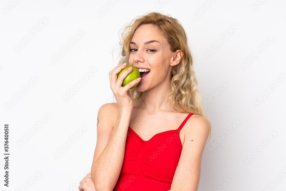 Young blonde woman isolated on white background eating an apple Young blonde woman isolated on white background eating an apple
