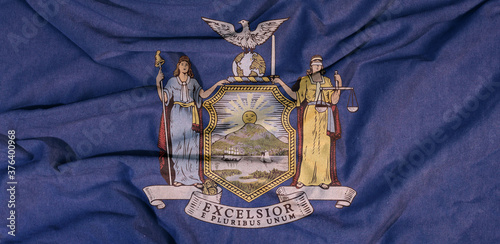 Flag of the American state flies in the wind. Colored background on fabric