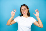Young beautiful woman over isolated blue background showing and pointing up with fingers number nine while smiling confident and happy
