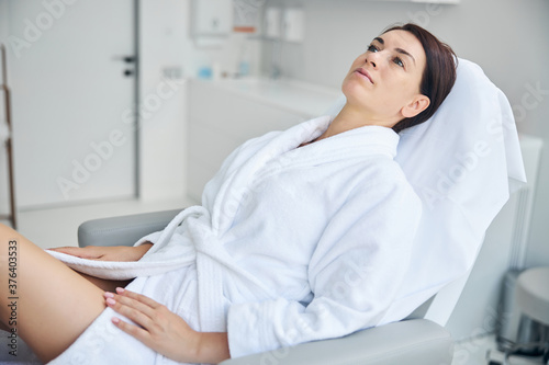 Attractive pensive adult spa client staring upward