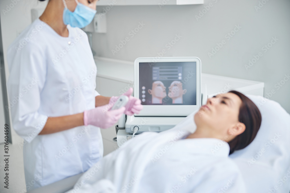 Dark-haired patient lying on the couch before a procedure Dark-haired patient lying on the couch before a procedure