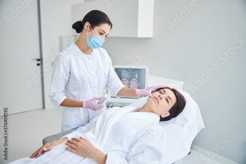 Qualified dermatologist in sterile gloves examining the patient