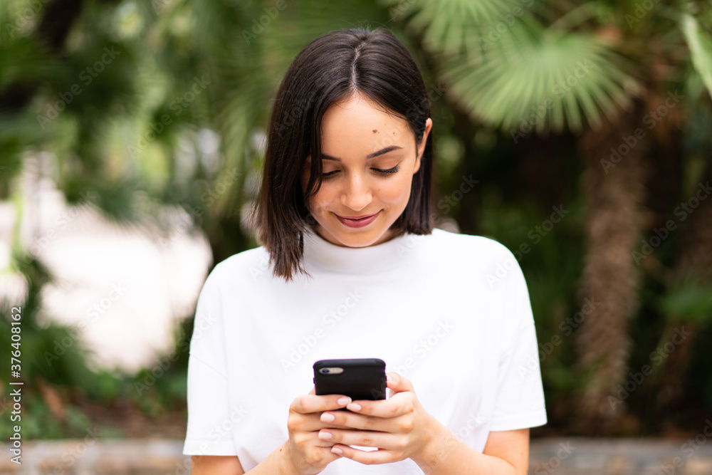 Young caucasian woman using a phone at outdoors Young caucasian woman using a phone at outdoors