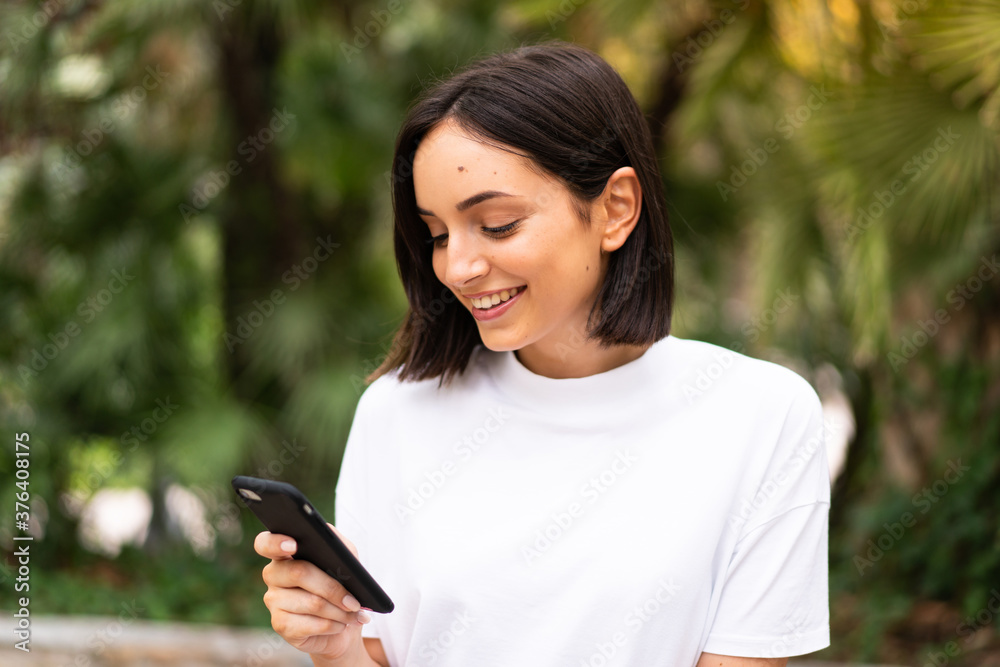 Young caucasian woman using a phone at outdoors Young caucasian woman using a phone at outdoors