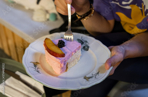 girl holding peach and berry mousse cake on plate