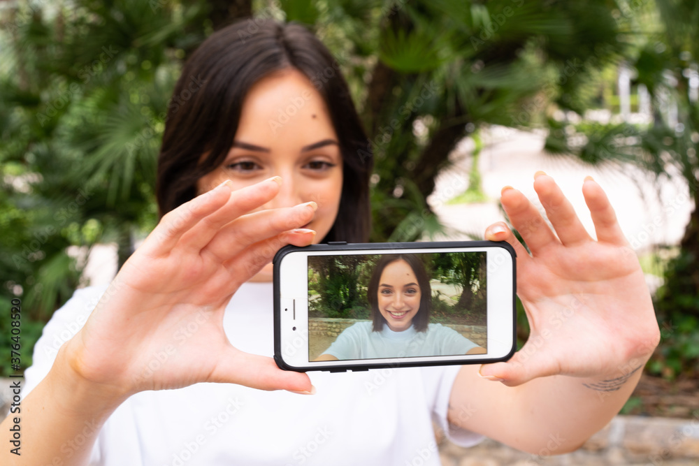 Young caucasian woman making a selfie at outdoors